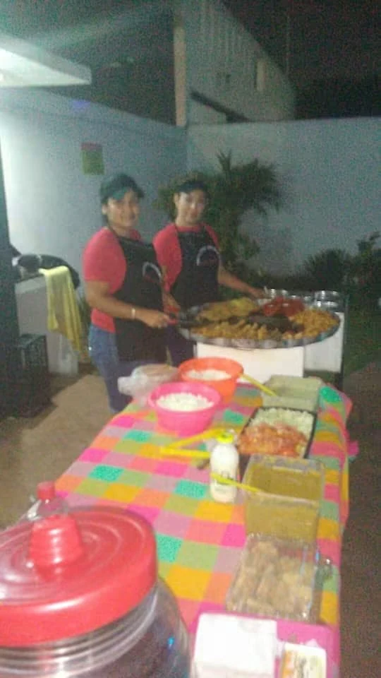 Personas preparando y sirviendo el buffet de antojitos mexicanos