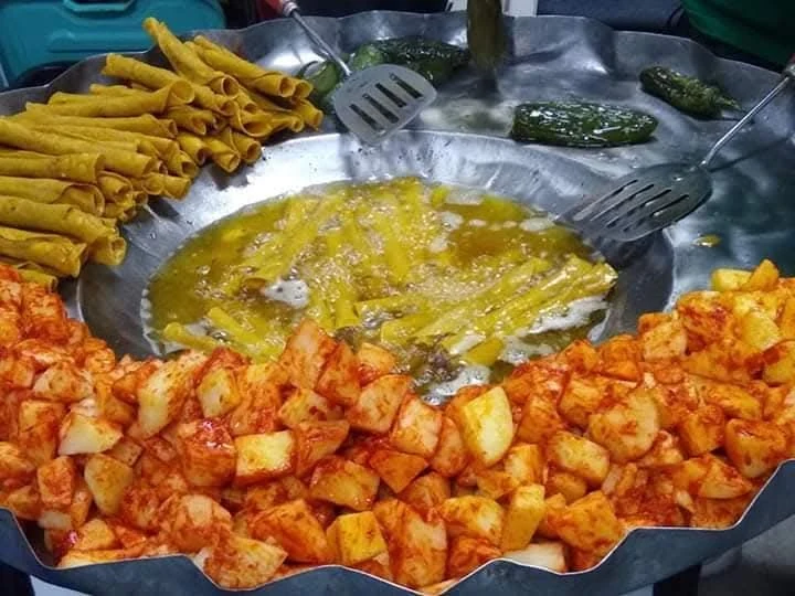 Flautas doradas junto a papas y chiles durante su preparación